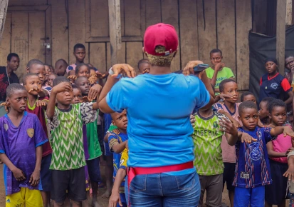 A facilitator leading a community outreach programme with children